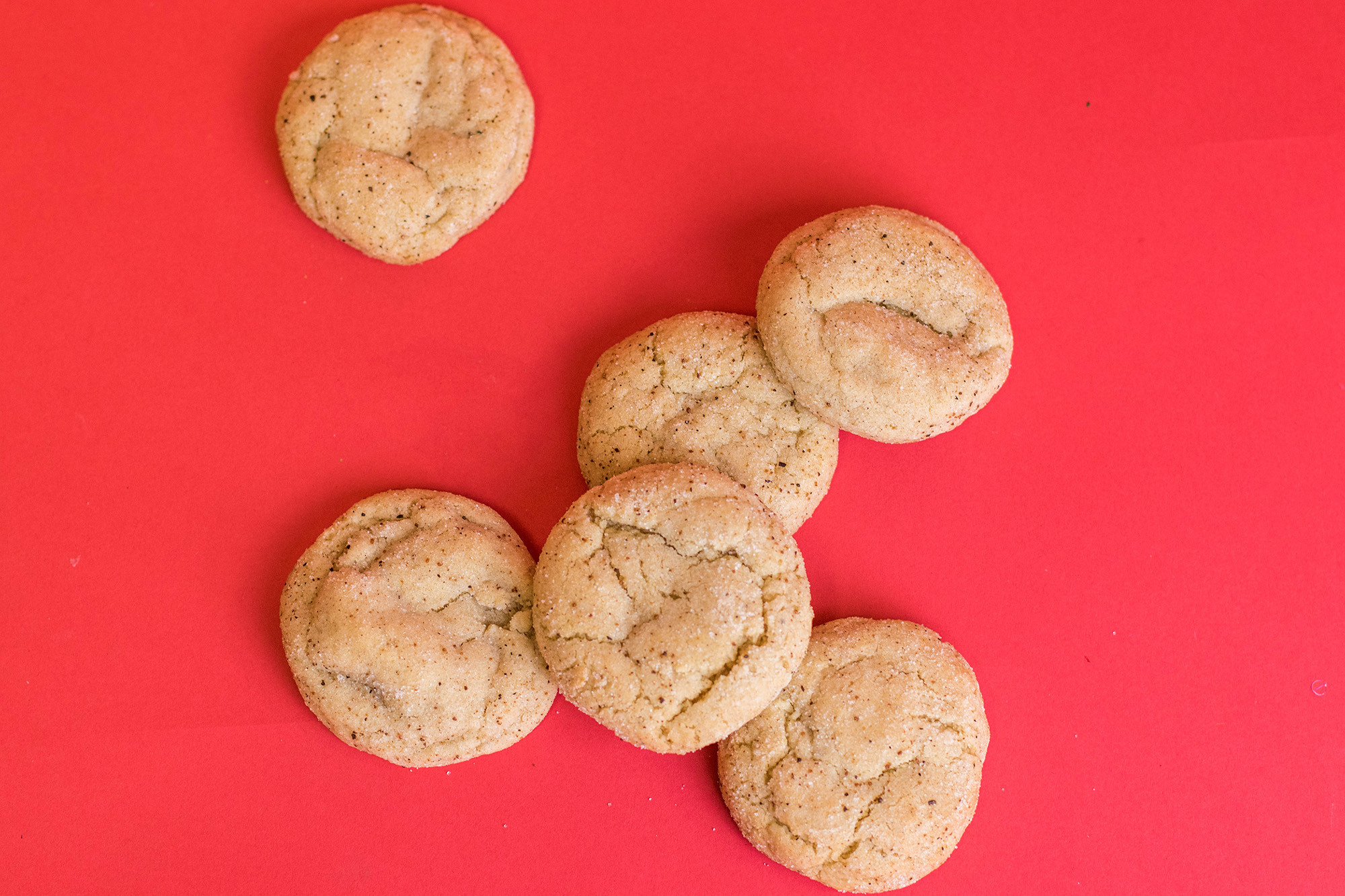 Egg Nog cookies spread out on a red background.